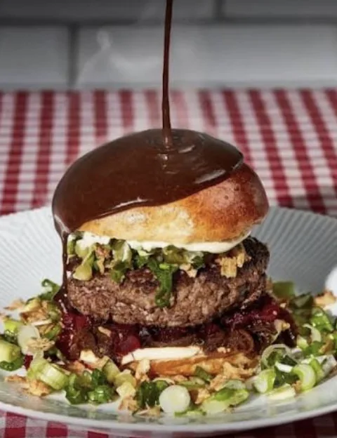 En af Grisens egne burgere serveret med friske toppings og sauce